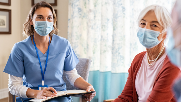 Home-Care - Krankenpflegerin die ein älteres Ehepaar berät 