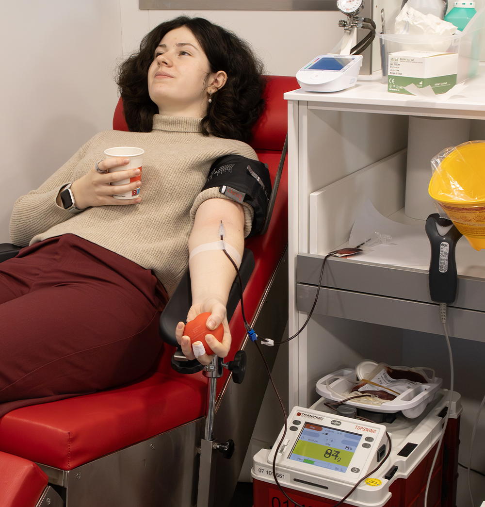 Mitarbeiterin liegt auf Liege und spendet Blut