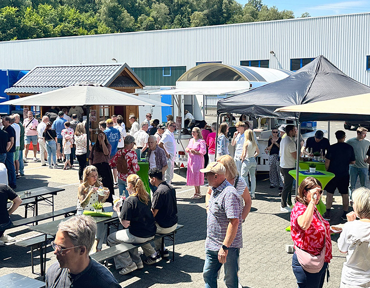 Belebter Außenbereich mit Gästen, Sitzplätzen und Ständen beim KLEIN Sommerfest 2026 auf dem Firmengelände in Wilnsdorf.
